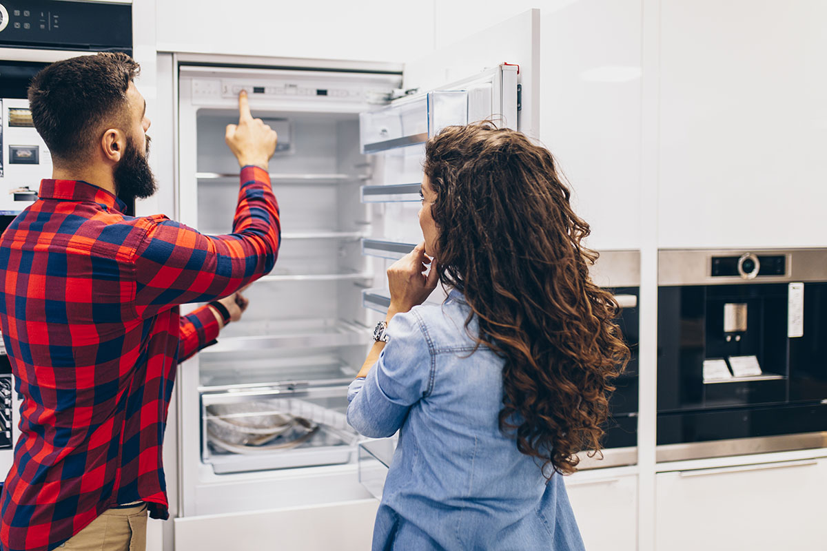 Young couple measuring their fridge